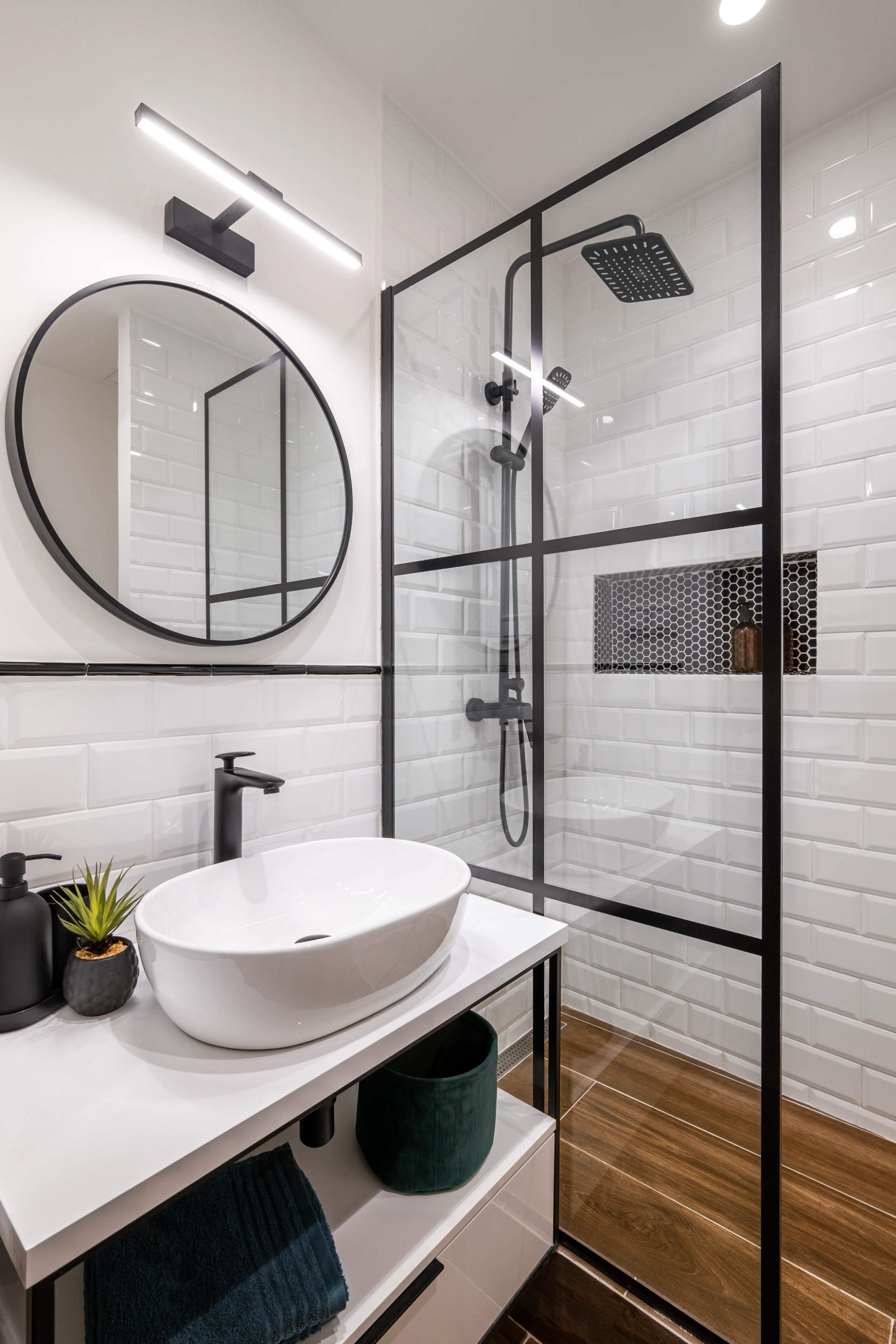 White subway tile shower with black grid glass screen